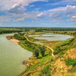 The Bow River curving past wetland ponds and a trail in Fish Creek Provincial Park, which borders McKenzie Lake to the west