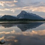Mount Rundle reflected in the calm water of First Vermilion Lake at sunrise in Banff National Park