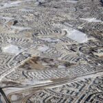 Aerial view in winter of the Arbour Lake neighbourhood in northwest Calgary, with the Crowchild Trail and Stoney Trail interchange